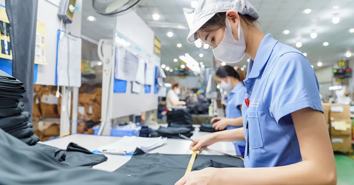 overseas clothing manufacturer sewing worker checking quality of garment